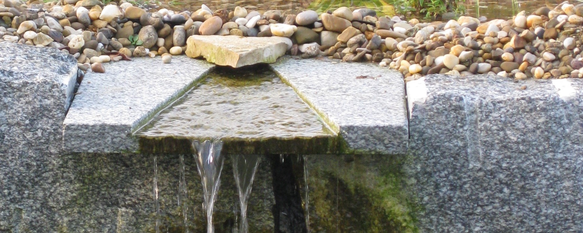 Der Wasserfall in die Natursteinmauer integriert